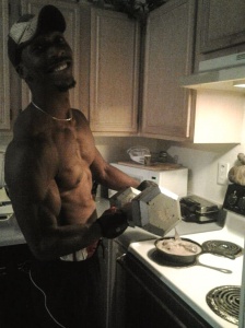 Michael Sanders, 29, is in the kitchen cooking and doing curls. ( Maresha Carrie copyright 2014) 